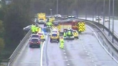 Car left dangling from motorway bridge after crash